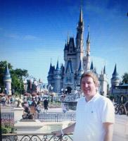 Teacher Joe Yoakum standing in front of the Disney Castle